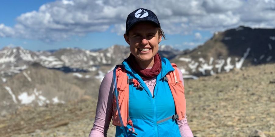 Cate Barrett at the top of a mountain peak after a 14 mile hike in Colorado.