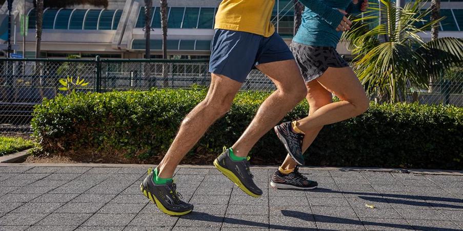 Two people running along a paved path. 