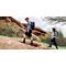 Two hikers carrying backpacks and walking up a hill on a trail.