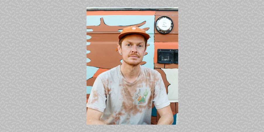 Wyatt Hersey, sitting on front of a colorful mural.