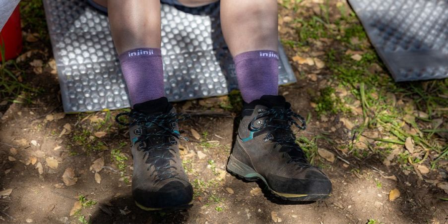 Hiker sitting down wearing the liner base layer in amethyst, 