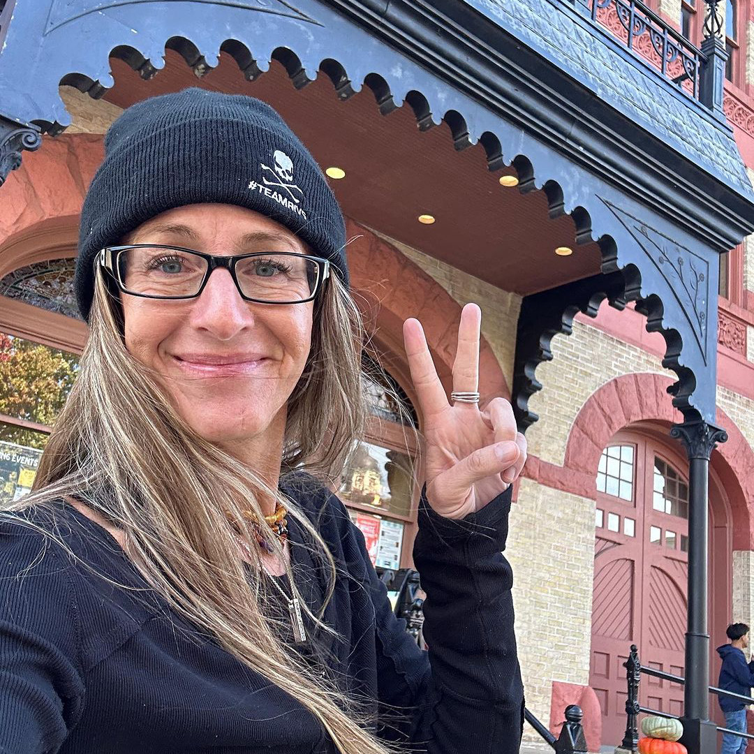 Karin Bachrodt taking a selfie in front of a historic city building.