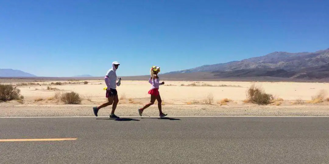 Two Team Injinji athletes running on an asphalt road at the Badwater 135 ultramarathon.