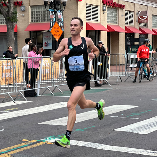 Dylan Marx races the San Diego Half Marathon while fans and bystanders watch. 