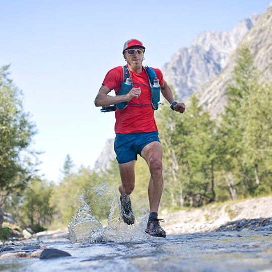 Team Injinji's Jeff Browning running through a creek.