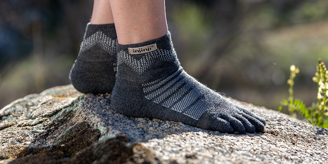 Feet wearing the Injinji Outdoor Midweight Mini-Crew wool socks. 