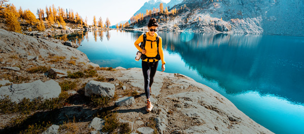 Person hiking on a trail next to a lake