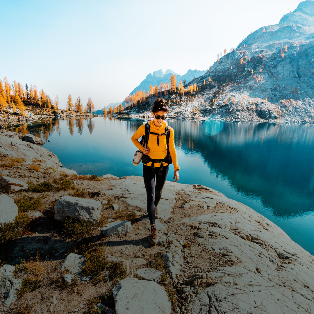 Person hiking on a trail next to a lake