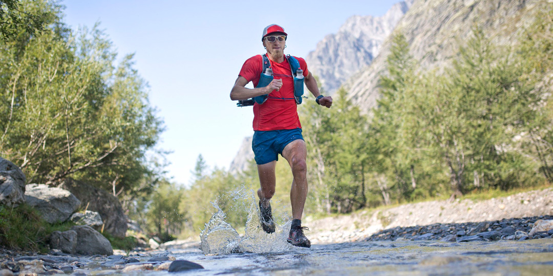 Team Injinji's Jeff Browning running through a creek.