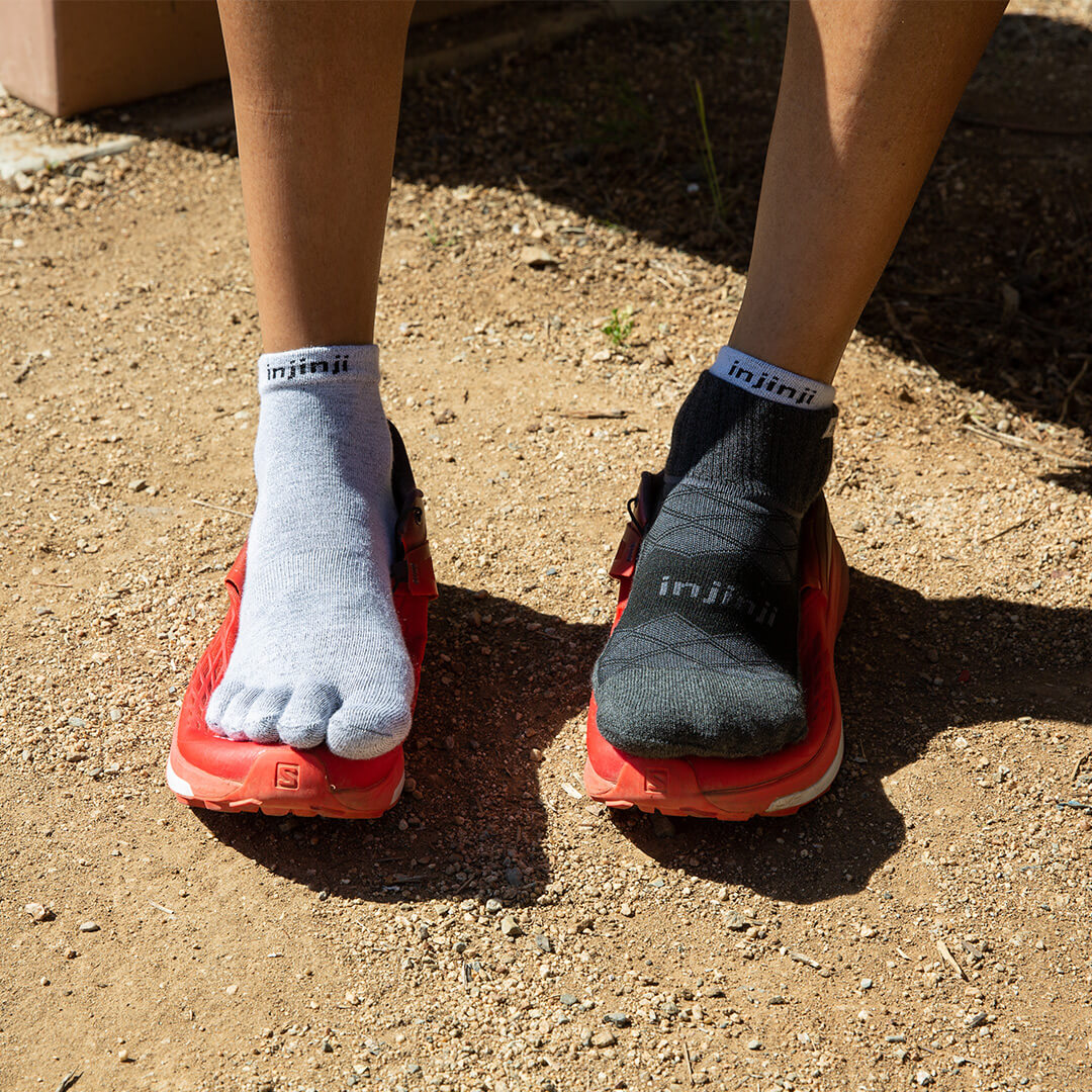 One foot showing a pair of running socks, another foot showing a pair of running toesocks