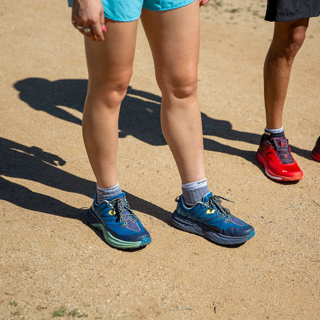 Two people running on a trail in ankle running socks