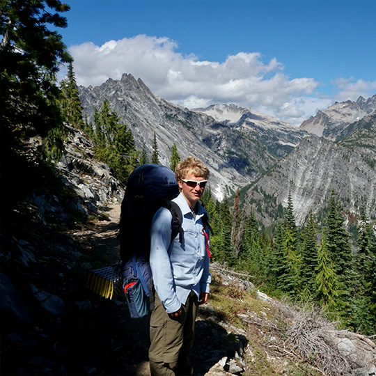 Male backpacker on a trail through the Cascade mountain range in Washington. 