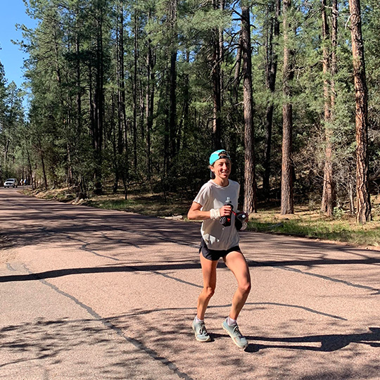 Female runner racing on a dirt trail in central Arizona. 